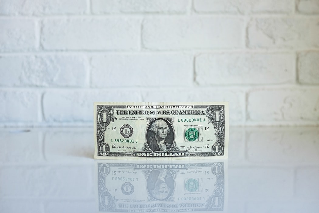 A dollar bill on a white surface.