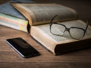 glasses, book and a phone on the table