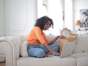 Black woman smiling while working on a laptop