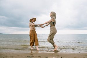 two women dancing on the beach