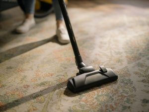 person vacuuming a rug