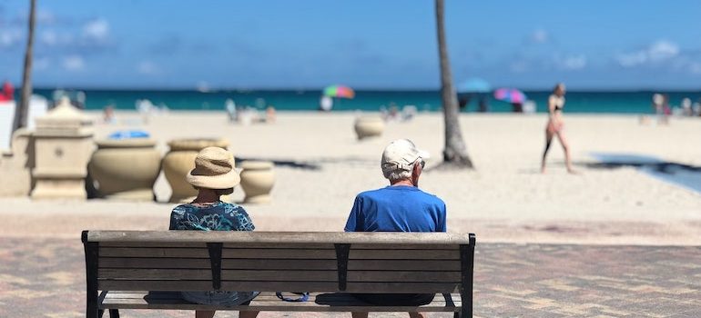 elderly couple on bench on a beach 