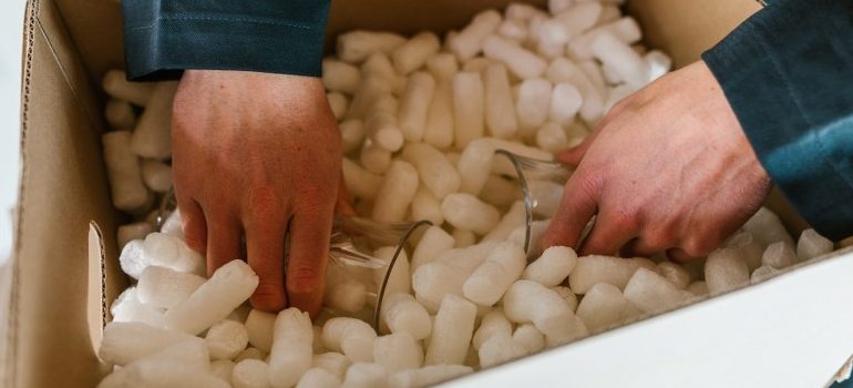 person packing a box with packing peanuts