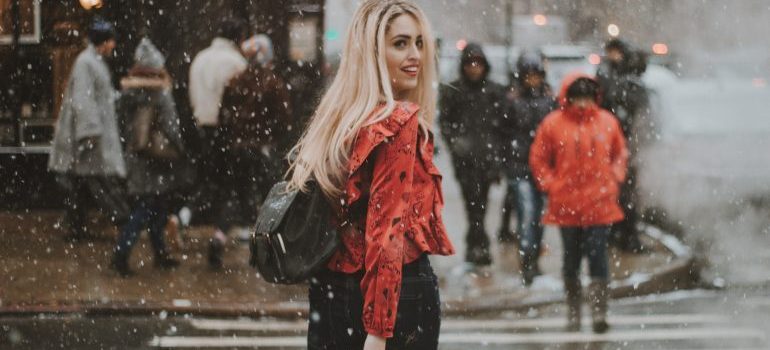 A woman on a street while it snows 