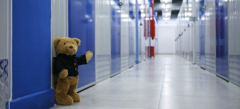 Blue storage units and a teddybear in the hallway.