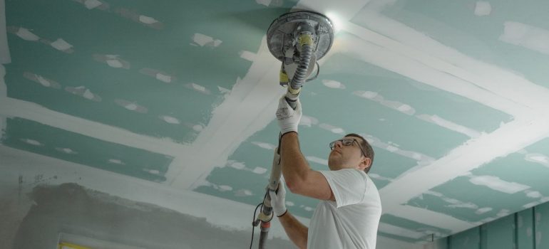 A man is polishing the ceiling while getting ready to prepare your new Boca Raton flat for moving in. 