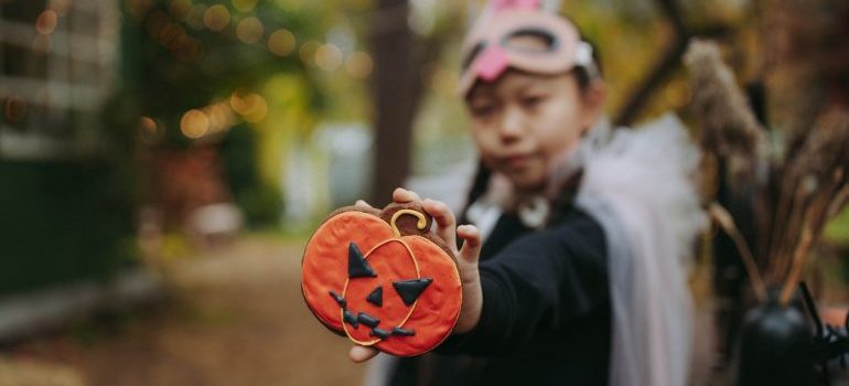Kid holding a Halloween pumpkin