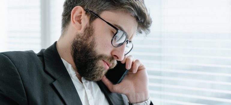 A man on a phone postponing his relocation