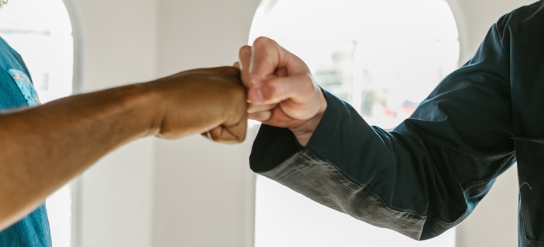 Two people greeting each other with fists