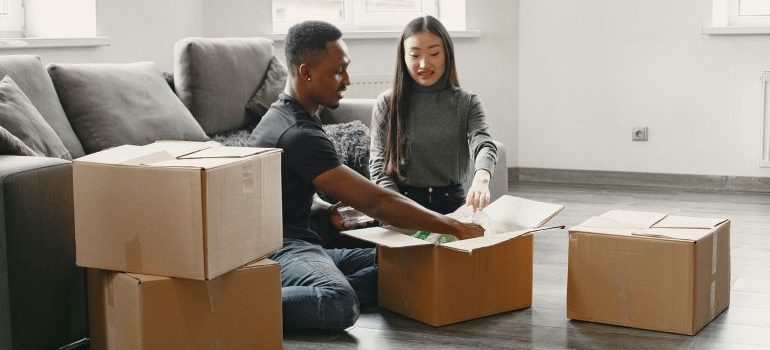 two people putting things into moving boxes 