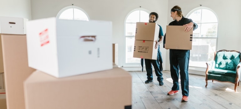 Men in Holding Brown Cardboard Box not making mistakes people make when moving to Boca Raton