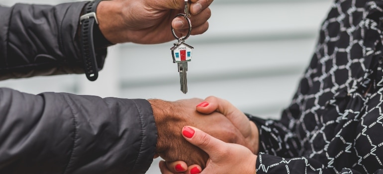 person giving the house keys to another person