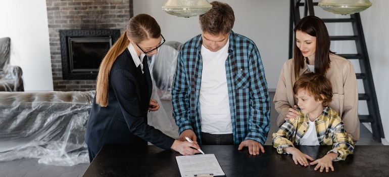 real estate agent and family signing papers