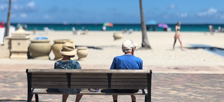 elderly couple sitting by the beach
