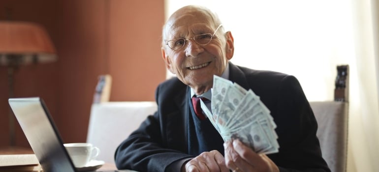 An old man holding some cash