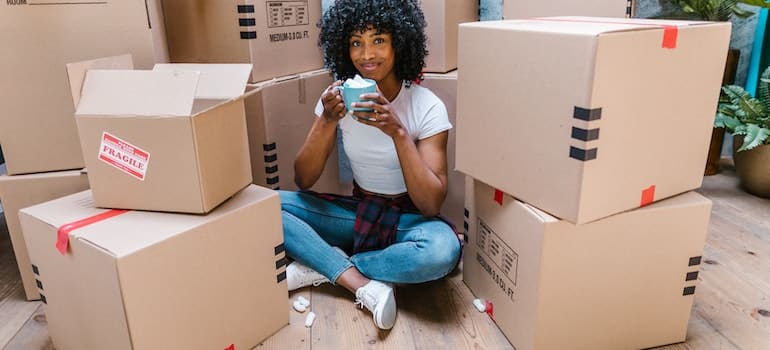 woman sitting between cardboard boxes